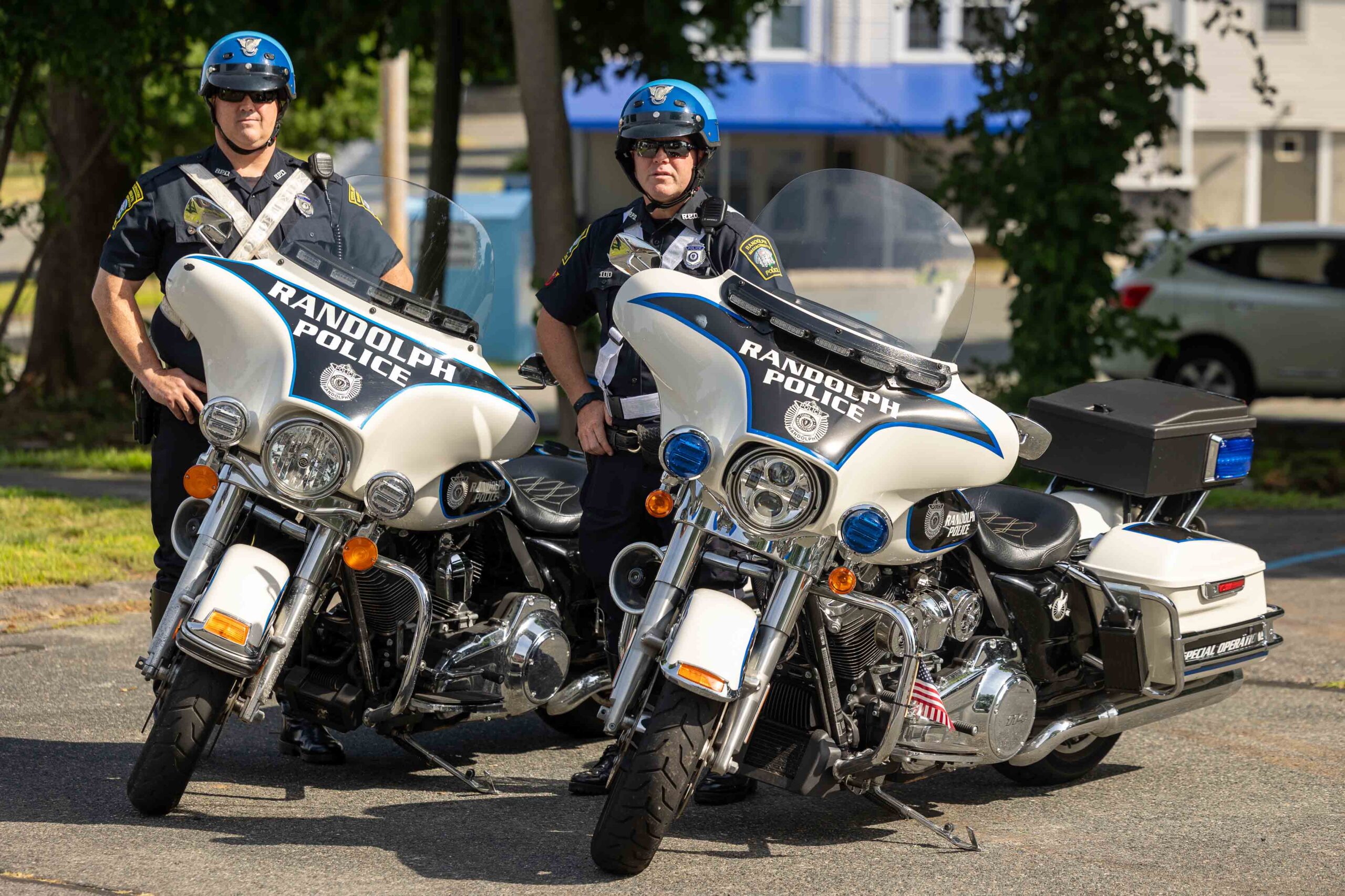 Two police officers stand next to Randolph PD Motorcycles
